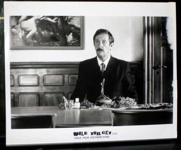 WILD TARGET: Publicity Still Man Sitting At Table WILD TARGET: Publicity Still Man Sitting At Table